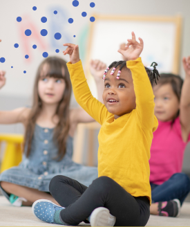 Three toddlers practicing yoga with their arms above their heads.